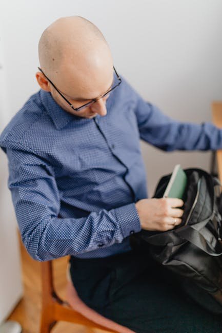 Office worker packing a gym bag at the end of the day, focused and ready to train.