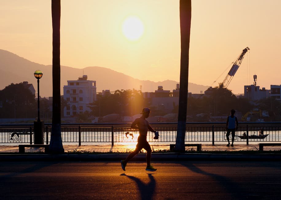 Runner hydrating on a riverside path at sunset, managing energy for daily training.