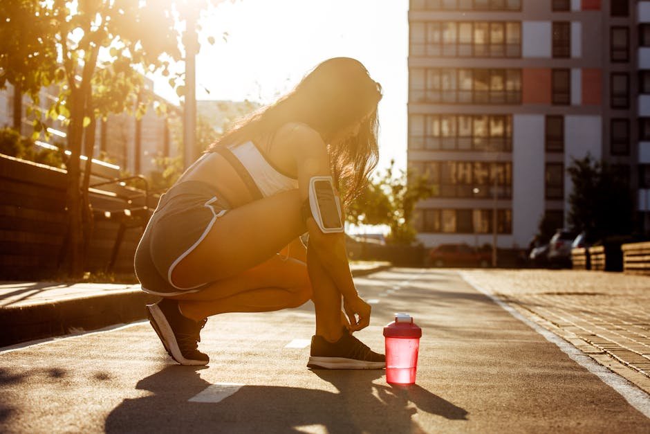 Woman lacing up on a quiet dawn sidewalk, determined to start moving.