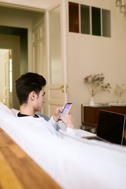 Tired person sitting on couch scrolling phone